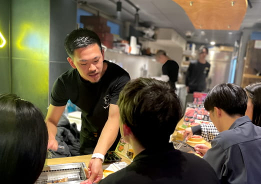 男性店員がお客様に商品を提供している様子