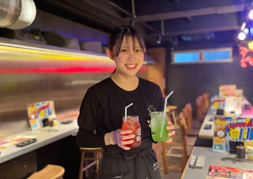 女性店員が笑顔で飲み物を提供している様子